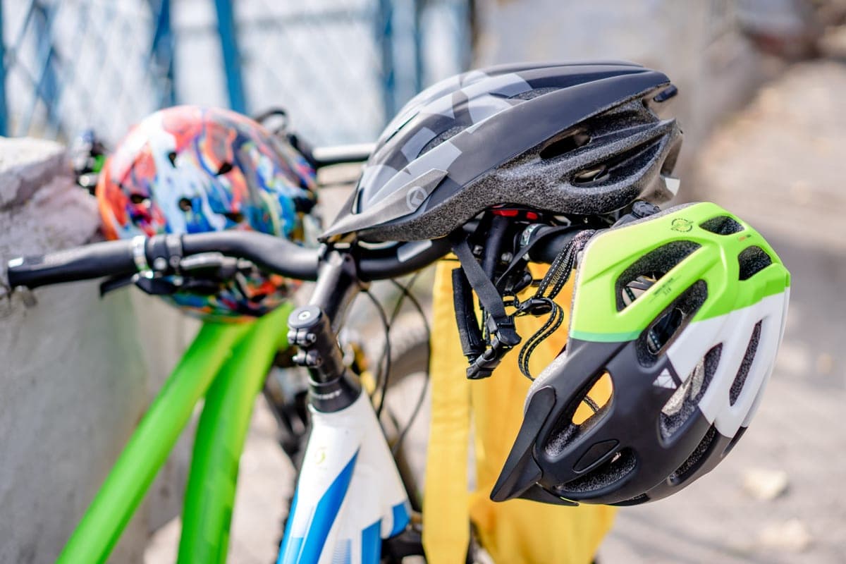 Brightly colored bicycle helmets resting on handlebars